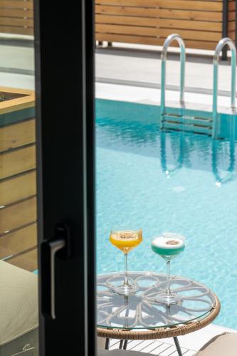 a table with two chairs and a swimming pool at Georgioupolis Suites & Aqua Park in Georgioupolis