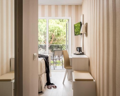 a room with a bed and a desk and a window at Estival Centurión Playa in Cambrils