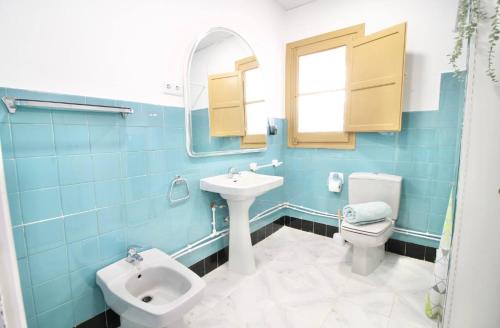 Un baño con lavabo, inodoro y espejo. en Lo Xalet de les Cases, en Les Cases d'Alcanar