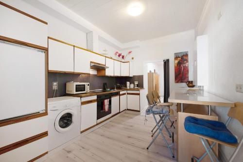 a kitchen with white cabinets and a washer and dryer at an der Mosel in Kaisersesch