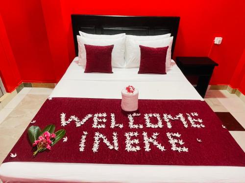 a red bedroom with a bed with a welcome anniversary blanket at Hema Holiday Villa in Trincomalee