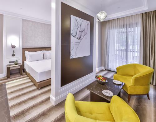 a hotel room with a bed and a couch and a chair at Narven Wellness & Thermal Hotel in Yukarımahalle