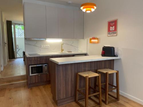- une cuisine avec un comptoir et deux tabourets dans l'établissement Un air de Seventies avec grande terrasse, à La Rochelle