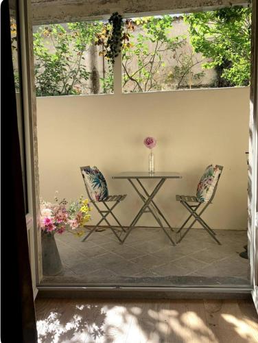 d'une terrasse avec une table et deux chaises. dans l'établissement Un air de Seventies avec grande terrasse, à La Rochelle