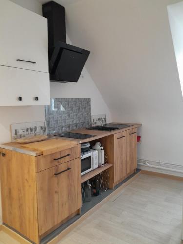 - une cuisine avec des placards en bois et une cuisinière dans l'établissement Bel F1 calme et central, à Gournay-en-Bray