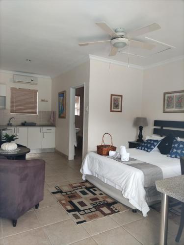 a bedroom with a bed and a ceiling fan at @47 Guest House in Gqeberha
