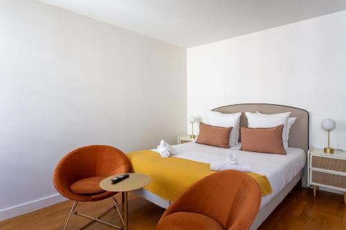 une chambre avec un lit et deux chaises dans l'établissement Marcel s Madeleine, à Paris
