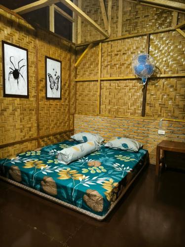 a bedroom with a bed with a blue comforter at Sama Sama Homestay & Trekking Only Stay Here Book Trekking and Transport With Us in Bukit Lawang