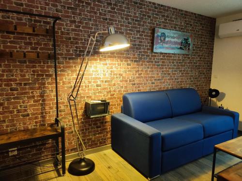 un salon avec un canapé bleu et une lampe dans l'établissement Appartement climatisé Le cap d'Agde, au Cap d'Agde
