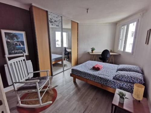 une chambre avec un lit et une chaise dedans dans l'établissement Charmant T3 entre port et centre-ville, proximité gare, à Brest