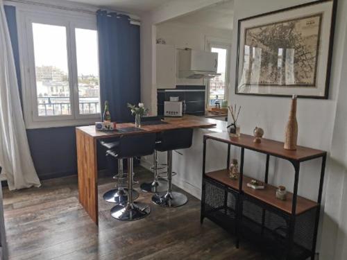 Cette chambre comprend un bureau et deux tabourets de bar. dans l'établissement Charmant T3 entre port et centre-ville, proximité gare, à Brest