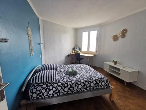 une chambre avec un lit et un mur bleu dans l'établissement Charmant T3 entre port et centre-ville, proximité gare, à Brest