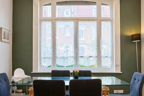 une salle à manger avec une table en verre et une fenêtre dans l'établissement Beautiful 1900 house full equipped, 4bdrm+ garden!, à Lambersart