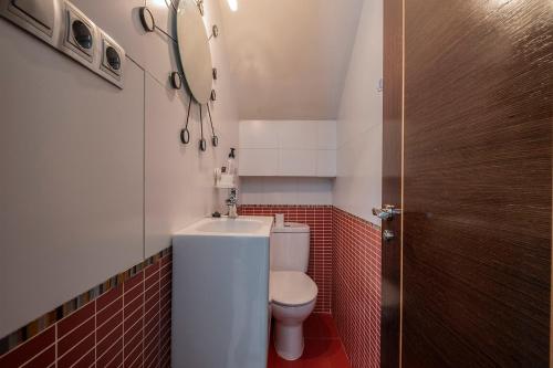 a small bathroom with a toilet and a sink at Casa Capricho in San Martín de Valdeiglesias
