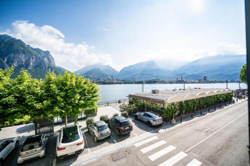a parking lot with cars parked next to a body of water at Renzo & Lucia Living Lake in Malgrate