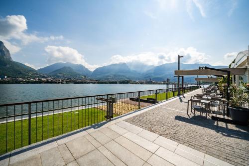 a patio with a view of a lake and mountains at Renzo & Lucia Living Lake in Malgrate
