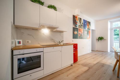 a kitchen with white cabinets and a stove top oven at Renzo & Lucia Living Lake in Malgrate