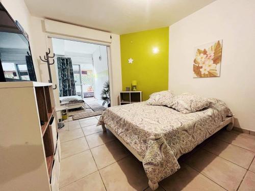 a bedroom with a bed in a room with a tv at Le nid d'amour avec sa piscine et jacuzzi chauffés in Saint-Joseph