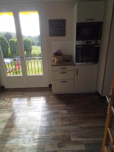 a kitchen with an open door to a balcony at La Reposee in Larchamp