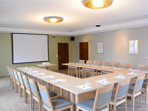 a conference room with a long table and chairs at Hotel Restaurant "Zur Post" in Holdorf