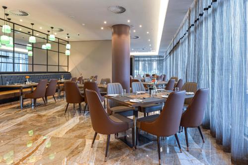 a restaurant with tables and chairs in a room at Coastlands Skye Hotel, Ridgeside, Umhlanga in Durban