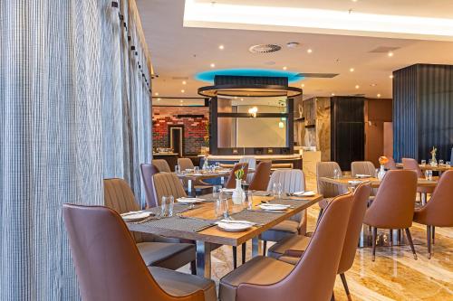 a restaurant with tables and chairs and a kitchen at Coastlands Skye Hotel, Ridgeside, Umhlanga in Durban