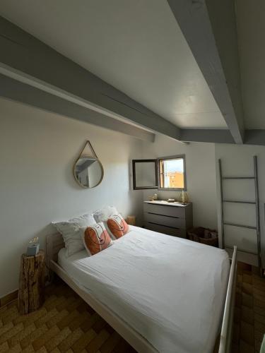 une chambre avec un grand lit blanc avec deux oreillers dans l'établissement Location à la semaine bel appartement Cap D agde, au Cap d'Agde