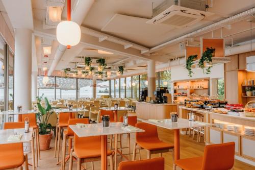 a restaurant with tables and chairs and a cafeteria at Hotel Mona Ex-Eurotel in Montreux