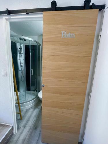 une porte en bois avec le mot bain écrit dessus dans l'établissement Superbe studio, NEUF, st Cyprien, à Toulouse