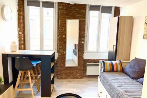 un salon avec un canapé et une table dans l'établissement Superbe studio, NEUF, st Cyprien, à Toulouse