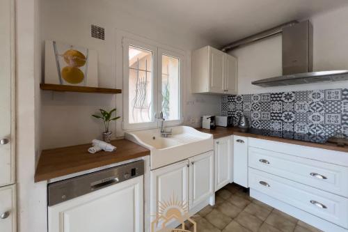 une cuisine blanche avec un évier et une fenêtre dans l'établissement LES GUIOLS Villa AirCo for 8 By Sunset, à Le Rouret