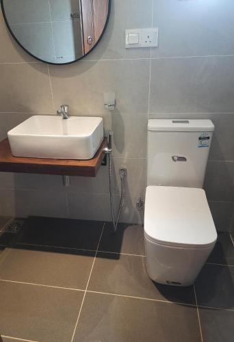 a bathroom with a white toilet and a sink at Villa A50 in Negombo
