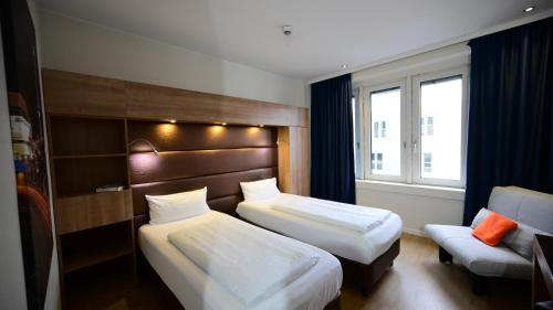 a hotel room with two beds and a couch at Motel Plus Berlin in Berlin