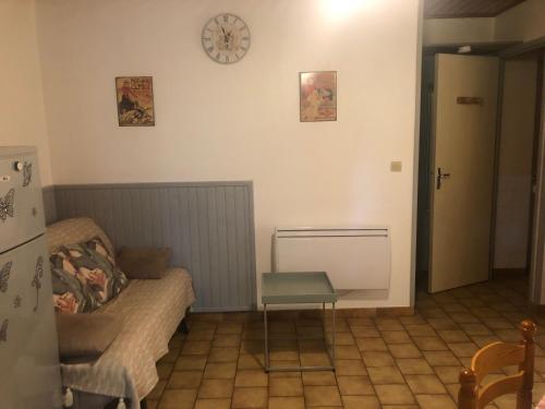 un salon avec un canapé et une horloge au mur dans l'établissement Clairière, à Cazaubon