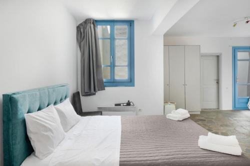 a bedroom with a large bed with a blue headboard at Efrossyni House in Ioulida