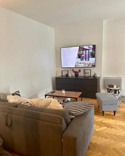 un salon avec un canapé et une télévision à écran plat dans l'établissement Break à deux pas de paris, à Puteaux