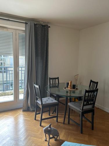 une salle à manger avec une table et un chat par terre dans l'établissement Break à deux pas de paris, à Puteaux
