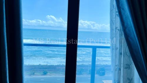 a view of the ocean from a window at M8 Ocean King Three Bed Apartment in Cinnamon Gardens
