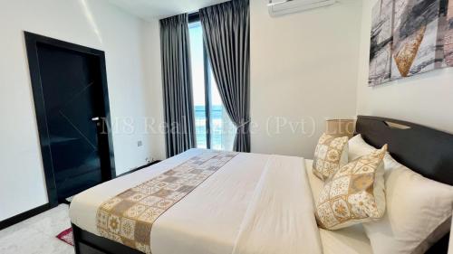 a bedroom with a bed with a large window at M8 Ocean King Three Bed Apartment in Cinnamon Gardens