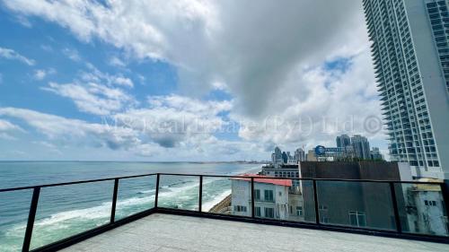 a view of the ocean from the balcony of a building at M8 Ocean King Three Bed Apartment in Cinnamon Gardens