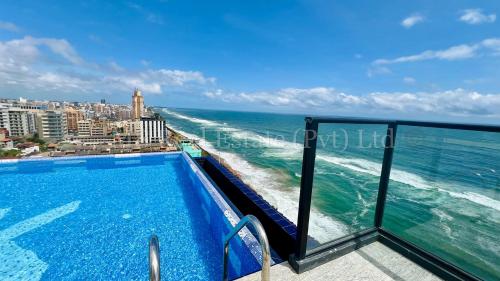 a swimming pool on the roof of a building overlooking the ocean at M8 Ocean King Three Bed Apartment in Cinnamon Gardens