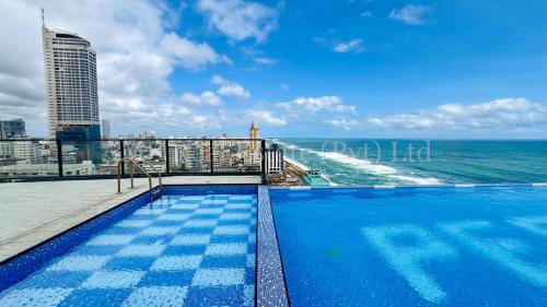 a swimming pool on top of a building next to the ocean at M8 Ocean King Three Bed Apartment in Cinnamon Gardens