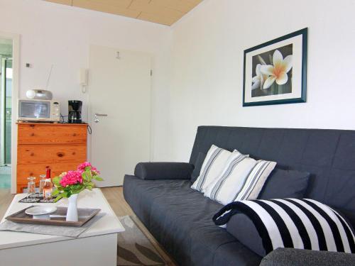 a living room with a couch and a table with flowers at Wohnung in Neubukow nahe Ostseestrand in Neubukow
