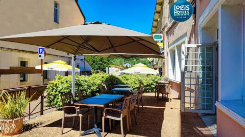 a table and chairs under an umbrella outside a building at Logis Grand Hotel Pelisson in Nontron