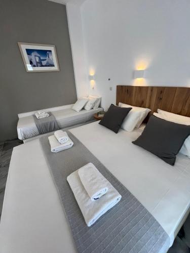 two beds in a room with towels on them at CAELI PAROS by Kostas & Joanna Studios in Logaras