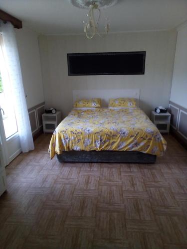 a bedroom with a bed and a wooden floor at La Reposee in Larchamp