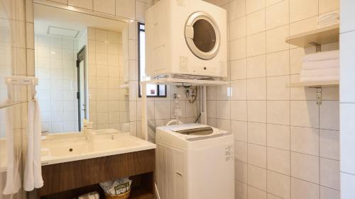 a bathroom with a sink and a washing machine at Rereso沖縄美ら海 in Motobu