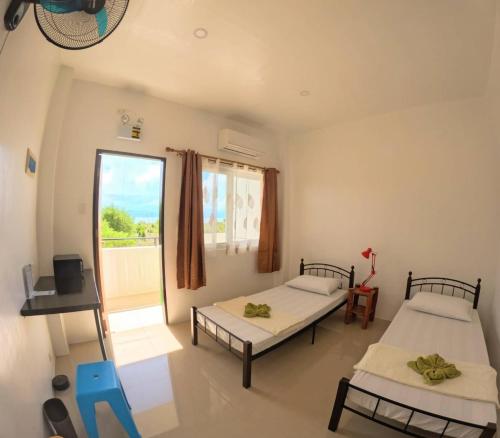 a room with two beds and a window at Divers Lodge Plumeria in Moalboal