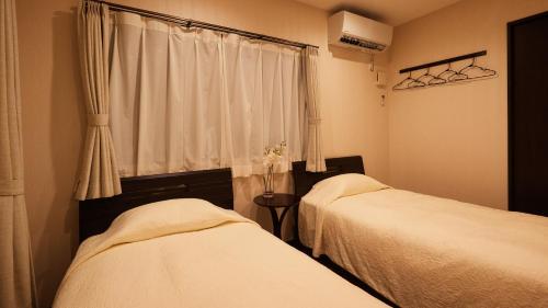 a bedroom with two beds and a window at Rereso沖縄美ら海 in Motobu