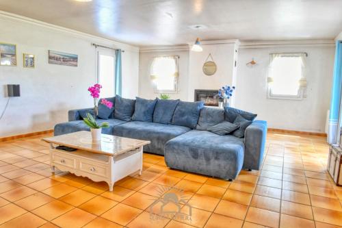 un salon avec un canapé bleu et une table dans l'établissement LES GUIOLS Villa AirCo for 8 By Sunset, à Le Rouret